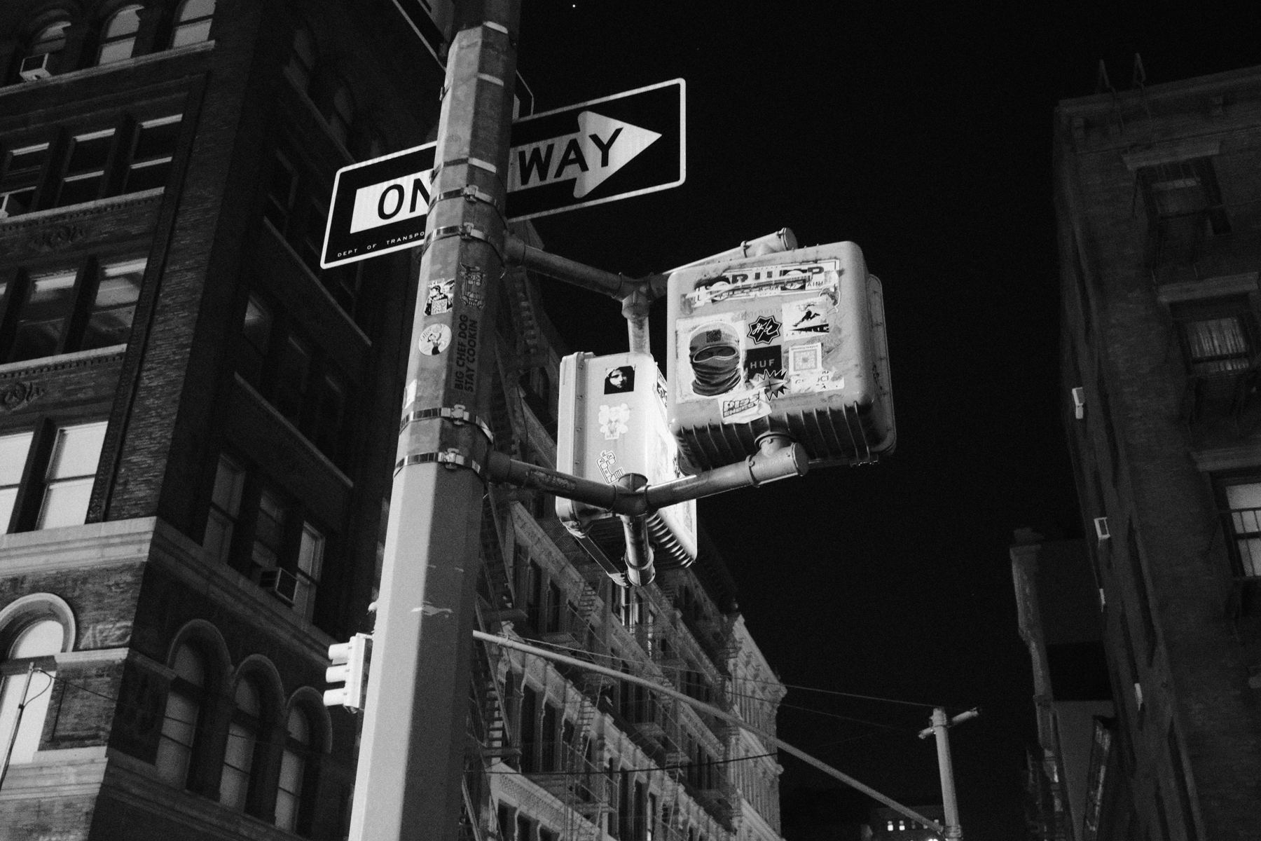 One-way sign against a night sky, black and white