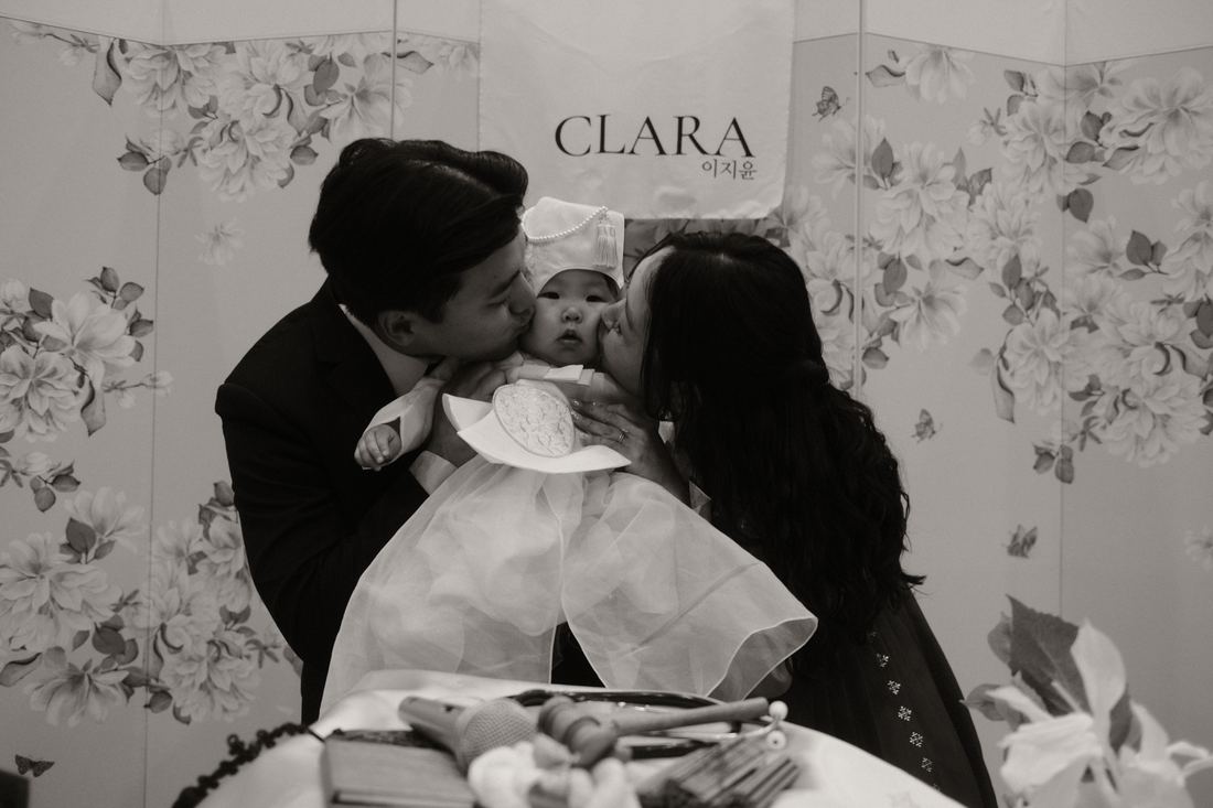 Parents kissing their daughter, black and white