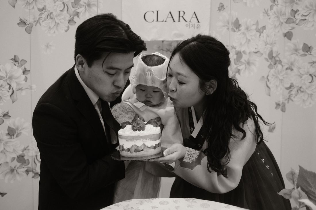 Parents blowing out the candle together, black and white