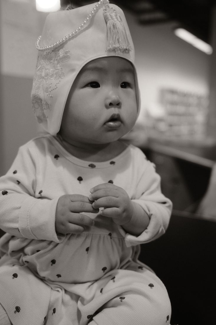 Baby in a bonnet looking up, black and white