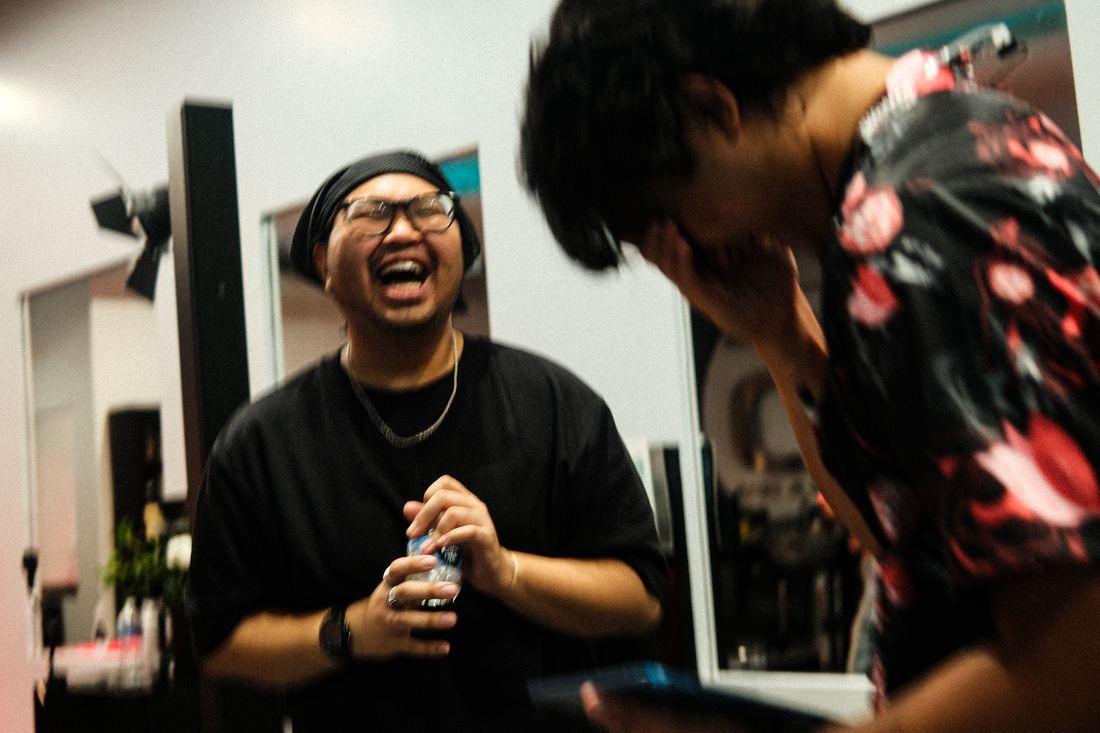 A guest laughing in a mirror-lit salon