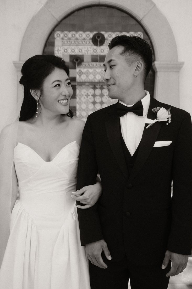Bride and groom arm in arm, black and white